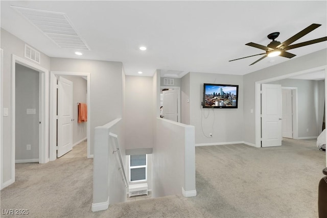 hall featuring an upstairs landing, visible vents, light carpet, and baseboards