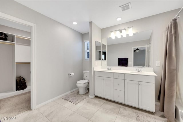 bathroom with double vanity, toilet, visible vents, and a sink