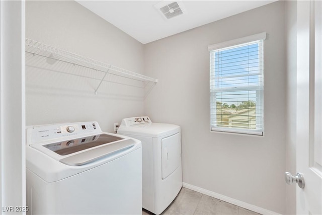 laundry area with light tile patterned floors, baseboards, visible vents, washing machine and clothes dryer, and laundry area