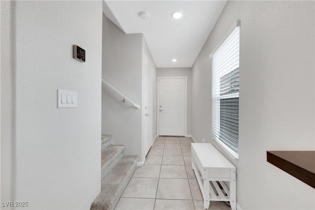 hall with light tile patterned floors, stairway, baseboards, and recessed lighting