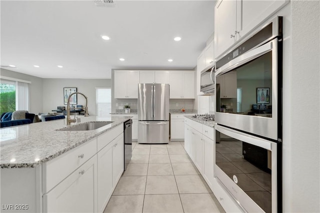 kitchen featuring a sink, plenty of natural light, appliances with stainless steel finishes, and white cabinets