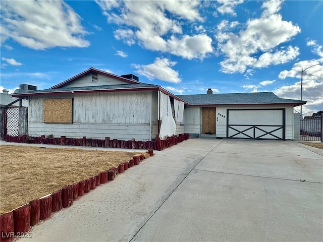 view of front of home featuring a garage, concrete driveway, and a front yard