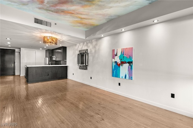 unfurnished living room featuring light wood-style flooring, recessed lighting, baseboards, and visible vents