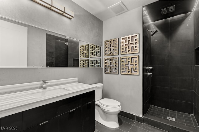 bathroom featuring tile patterned flooring, visible vents, toilet, tiled shower, and vanity