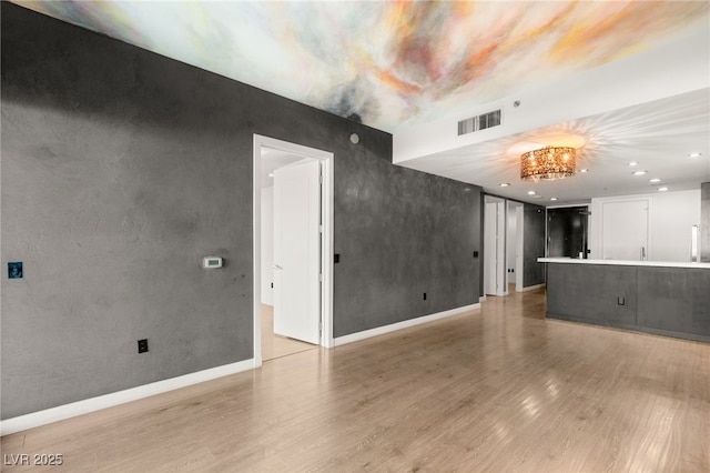 unfurnished living room with light wood finished floors, visible vents, recessed lighting, and baseboards