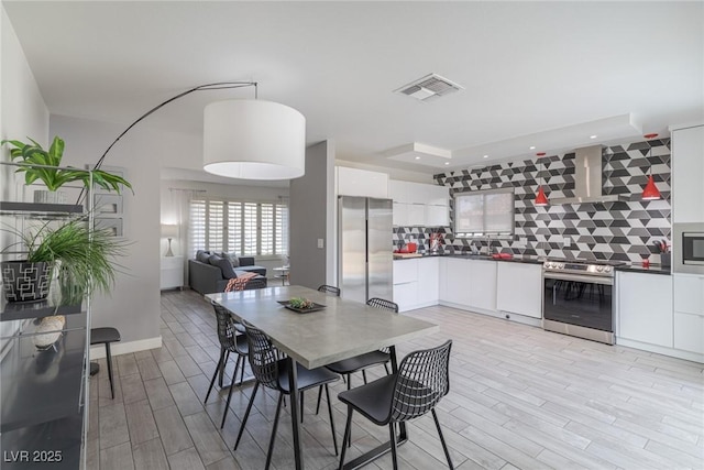 dining area with light wood-style flooring, recessed lighting, and visible vents