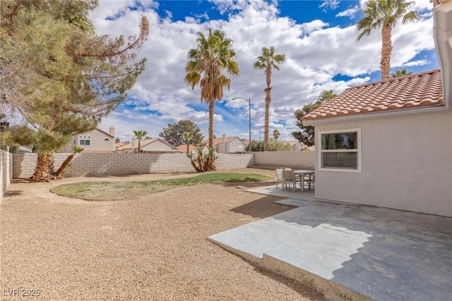 view of yard with outdoor dining space, a patio, and a fenced backyard