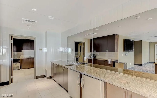 kitchen featuring visible vents, backsplash, and a sink