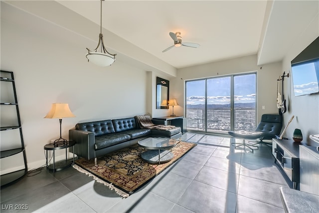 tiled living room featuring baseboards and a ceiling fan