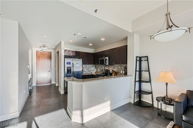 kitchen featuring stainless steel appliances, a peninsula, decorative backsplash, light stone countertops, and dark brown cabinets