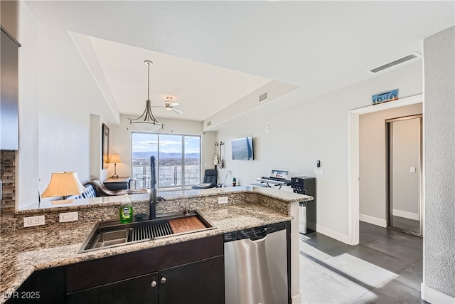 kitchen featuring stainless steel dishwasher, light stone counters, visible vents, and a sink