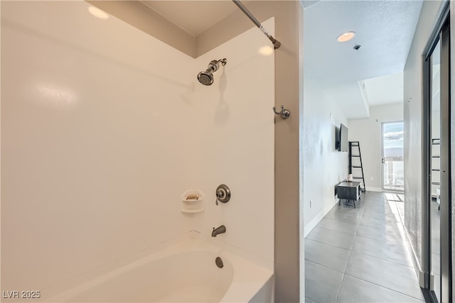 bathroom featuring tile patterned floors, baseboards, and shower / tub combination