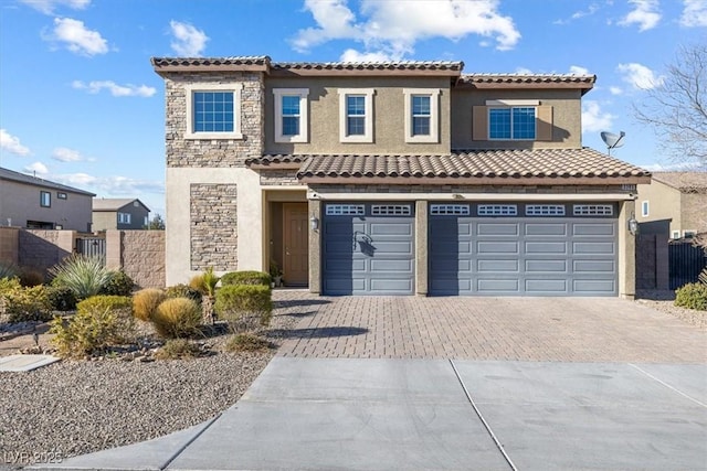 view of front facade featuring fence, an attached garage, stucco siding, stone siding, and decorative driveway