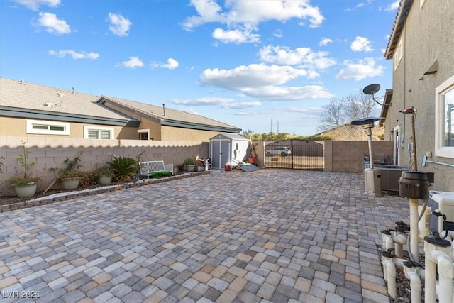 view of patio / terrace featuring an outdoor structure, a gate, a storage unit, and fence private yard