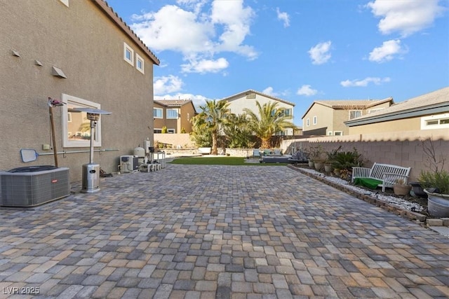 view of patio with a residential view, central AC, and fence