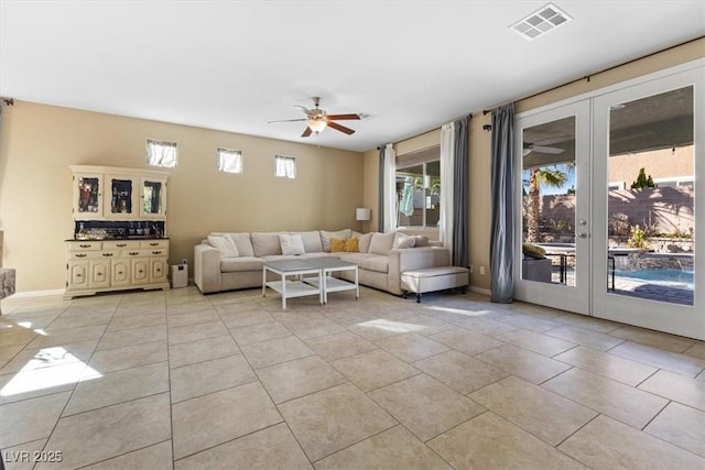 living room featuring visible vents, a ceiling fan, french doors, light tile patterned floors, and baseboards