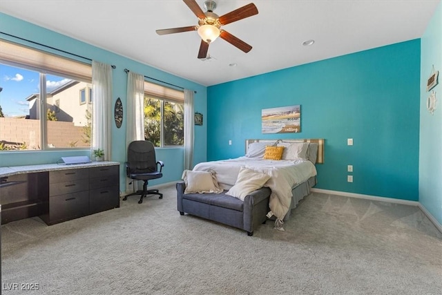 bedroom featuring baseboards, light colored carpet, and a ceiling fan