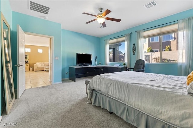 carpeted bedroom with tile patterned floors, visible vents, baseboards, and ceiling fan