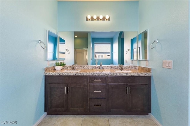 full bath featuring a sink, baseboards, and double vanity