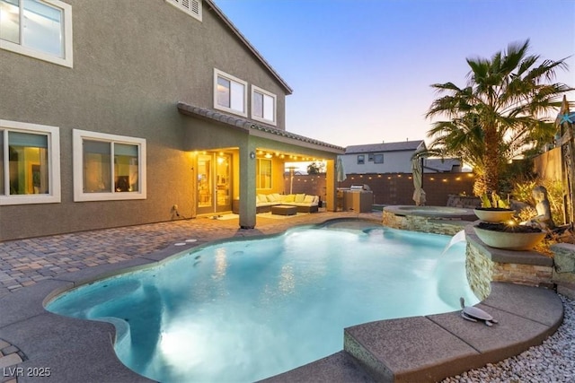 view of pool featuring a patio, a fenced backyard, a pool with connected hot tub, and an outdoor hangout area