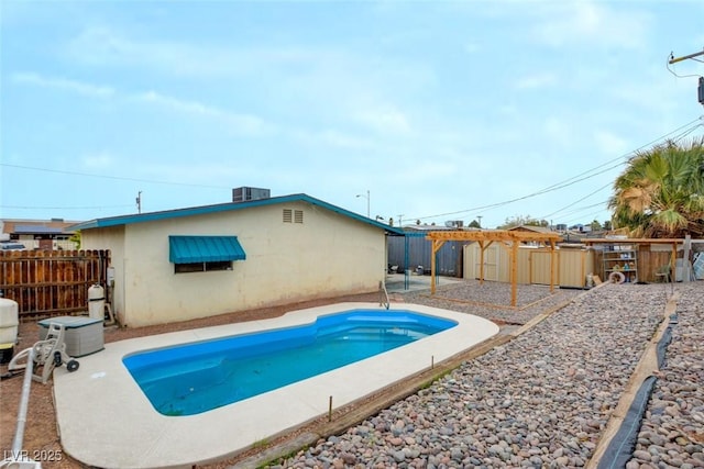 view of swimming pool with a storage unit, an outbuilding, central AC, a fenced backyard, and a fenced in pool