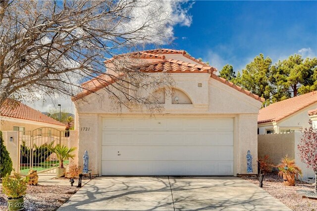 view of front of house with concrete driveway, a tiled roof, fence, and stucco siding