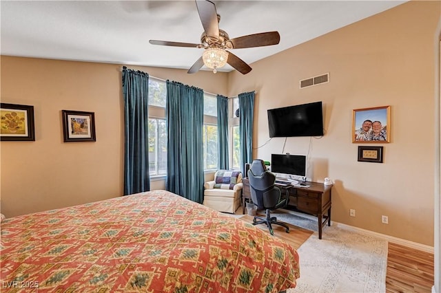 bedroom with visible vents, a ceiling fan, baseboards, and wood finished floors