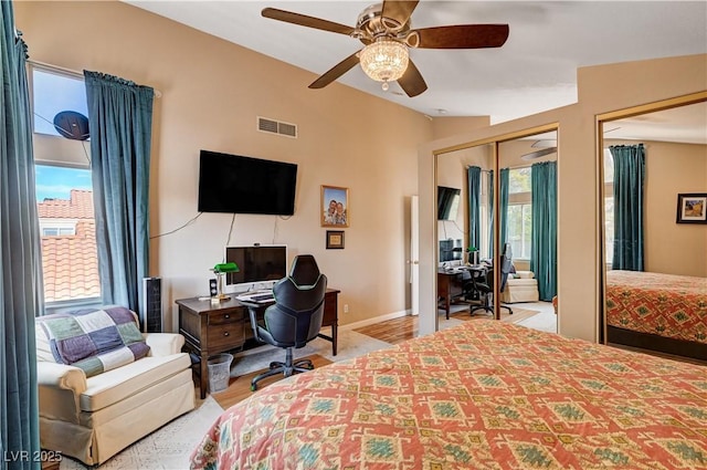 bedroom featuring visible vents, multiple windows, baseboards, and lofted ceiling