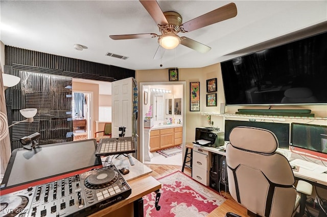 office space with visible vents, ceiling fan, and light wood-style flooring