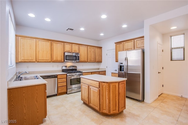 kitchen featuring a center island, light countertops, recessed lighting, appliances with stainless steel finishes, and a sink