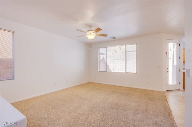 unfurnished room featuring light tile patterned floors, visible vents, a healthy amount of sunlight, and a ceiling fan