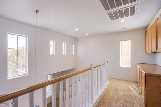 corridor with visible vents, baseboards, an upstairs landing, light carpet, and recessed lighting