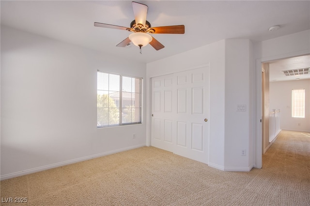 unfurnished bedroom with baseboards, visible vents, a closet, and light carpet