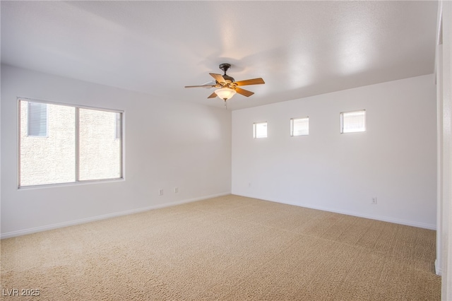 empty room with baseboards, light carpet, and ceiling fan