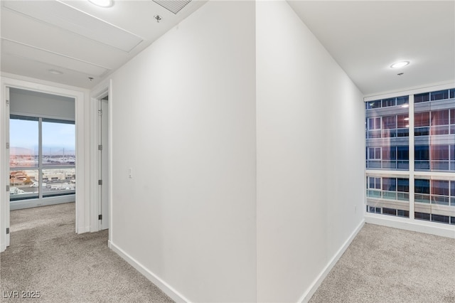 corridor featuring baseboards and carpet