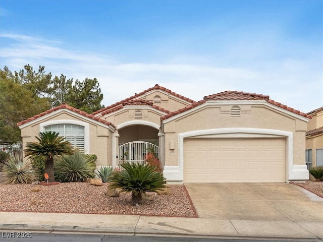 mediterranean / spanish house with stucco siding, driveway, a gate, a garage, and a tiled roof
