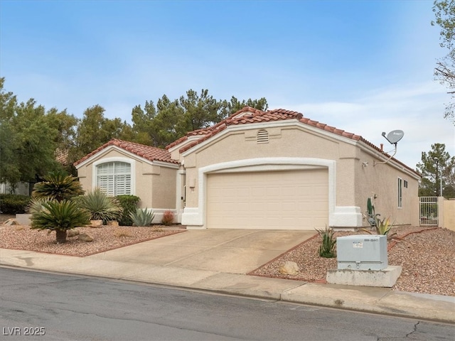 mediterranean / spanish-style home with stucco siding, driveway, a tile roof, and a garage