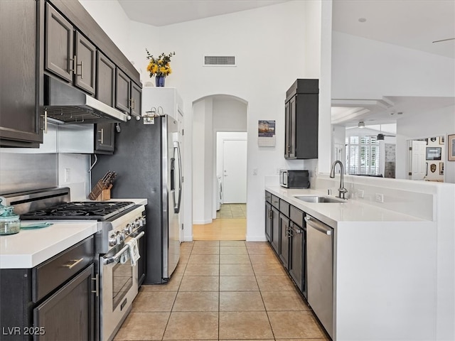 kitchen with visible vents, a sink, under cabinet range hood, stainless steel appliances, and light tile patterned floors