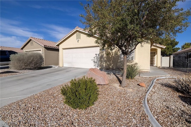 ranch-style home featuring fence, a tile roof, concrete driveway, stucco siding, and an attached garage