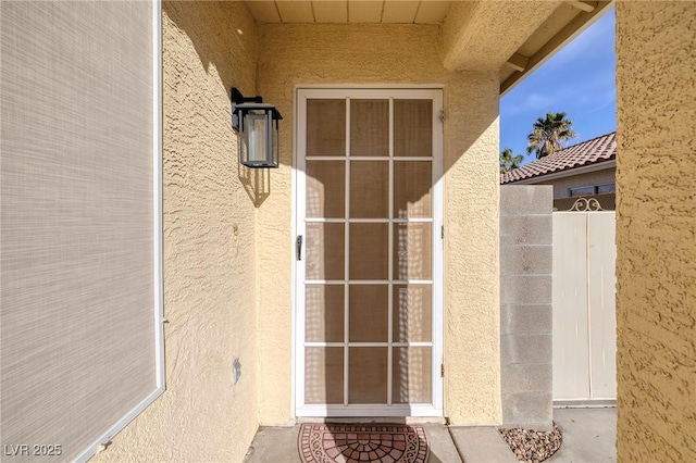 doorway to property featuring stucco siding