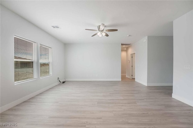 unfurnished room featuring visible vents, light wood-style floors, baseboards, and ceiling fan