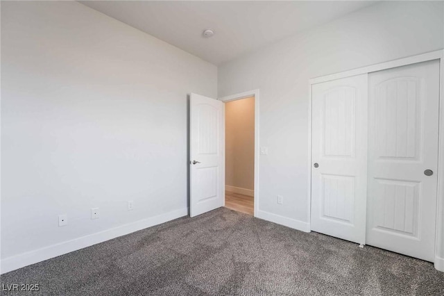 unfurnished bedroom featuring baseboards, carpet floors, and a closet