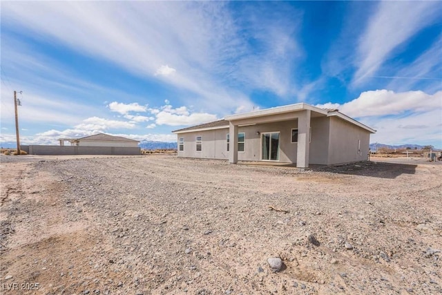 rear view of property featuring stucco siding