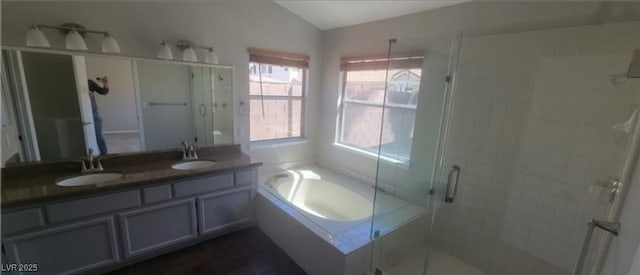 bathroom featuring lofted ceiling, a bath, a shower stall, and a sink