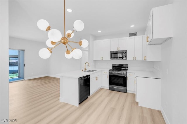 kitchen featuring light wood-style flooring, a sink, stainless steel appliances, an inviting chandelier, and light countertops