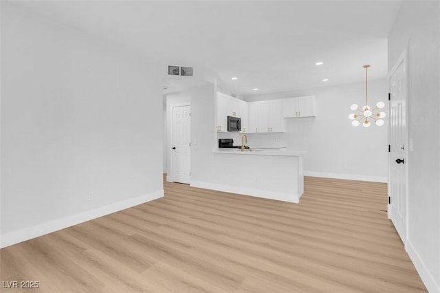 unfurnished living room featuring visible vents, baseboards, a chandelier, and light wood-style flooring