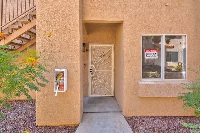 doorway to property featuring stucco siding