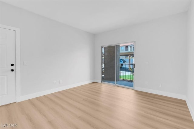 empty room featuring baseboards and light wood-style floors