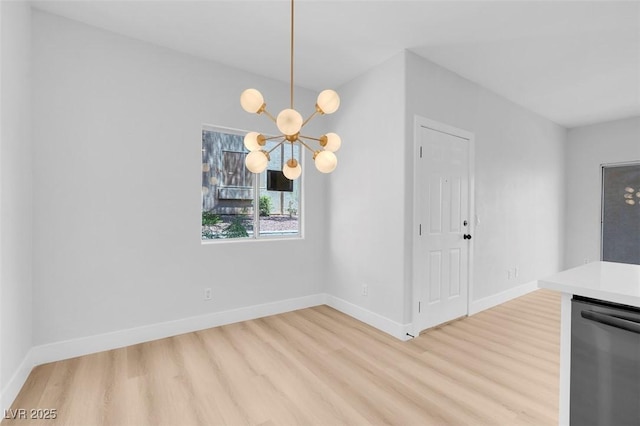 unfurnished dining area featuring a notable chandelier, baseboards, and light wood finished floors