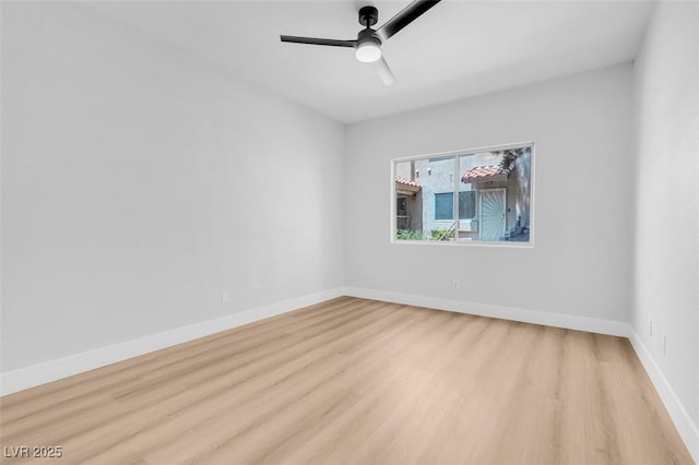 empty room with light wood-style flooring, a ceiling fan, and baseboards